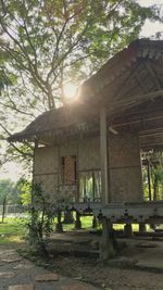 Built structure by trees and building against sky