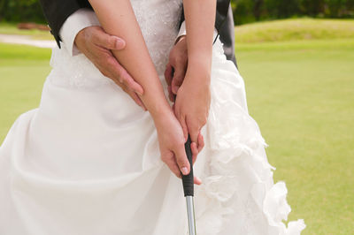 Midsection of couple playing golf