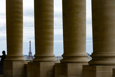 Side view of mature woman standing by architectural columns