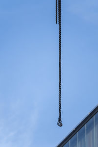 Low angle view of crane against clear sky