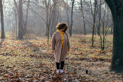 Rear view of woman standing in forest