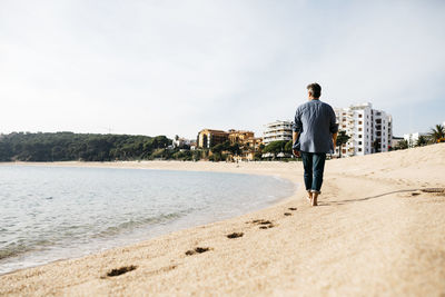 Man walking on beach during sunny day