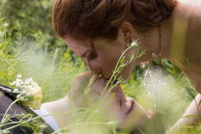 Couple kissing while lying on grass