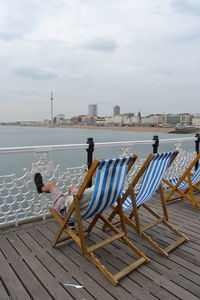 Man sitting on deck chair at brighton beach