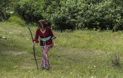 Full length of woman walking on grassy land