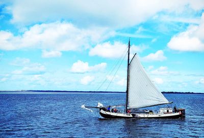 Sailboat sailing in sea against sky