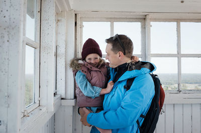 Father holding his daughter smiling whilst enjoying a beautiful view