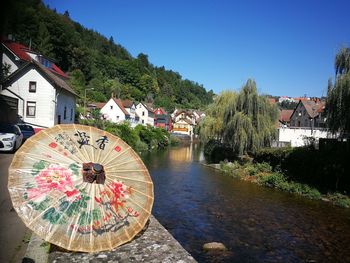 Traditional building by river against sky