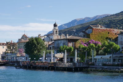 River by buildings in city against sky