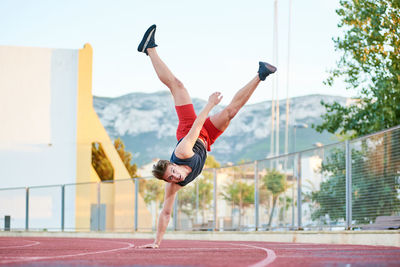 Low section of person with arms raised against the sky