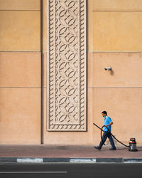 Full length of man walking against building