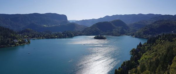 Scenic view of sea and mountains against clear sky