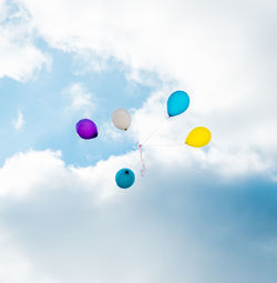 Low angle view of balloons against sky