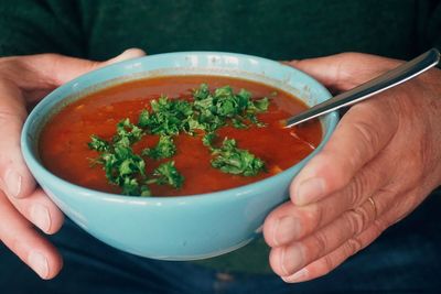 Midsection of man of holding soup bowl