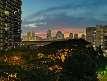 Buildings in city against sky at sunset