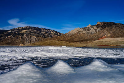 Scenic view of snowcapped mountains against blue sky