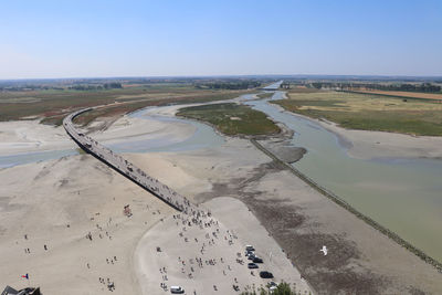 Aerial view of people on landscape by river against sky