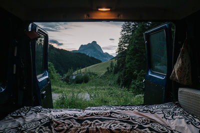 Scenic view of mountains against sky seen through window