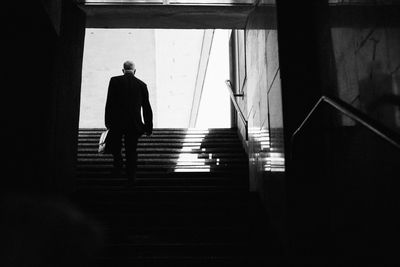 Low angle view of man moving up on steps in building