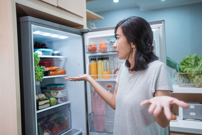 Woman standing in kitchen at home