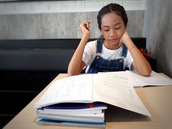 Girl studying on table at home