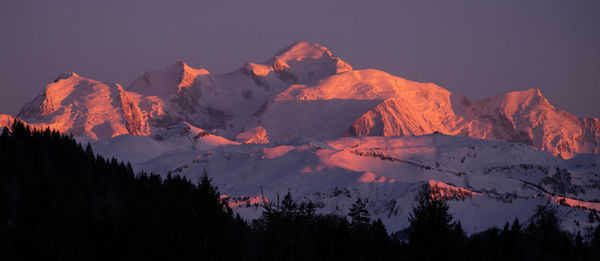 Scenic view of snowcapped mountains against sky at sunset