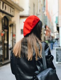 Rear view of woman with umbrella on street in city