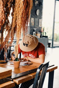 Side view of woman sitting on table