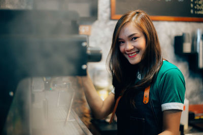 Portrait of smiling teenage girl standing in cafe