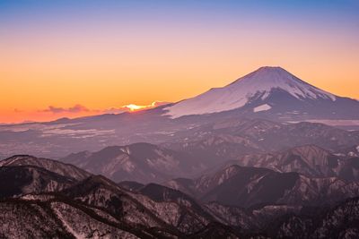 Scenic view of snowcapped mountains against sky during sunset