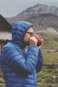 Midsection of man holding umbrella while standing on mountain