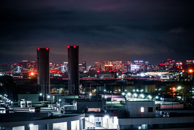 Illuminated cityscape against sky at night