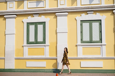 Full length of woman standing against building