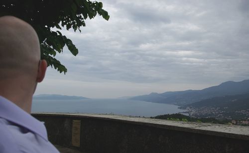 Rear view of man in sea against sky