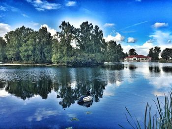 Reflection of trees in lake against blue sky