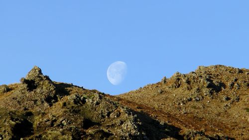 Low angle view of mountains against clear blue sky