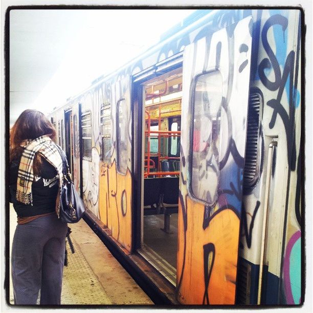 public transportation, transportation, lifestyles, men, architecture, train - vehicle, railroad station, transfer print, built structure, rail transportation, glass - material, standing, railroad station platform, indoors, auto post production filter, passenger train, travel, mode of transport