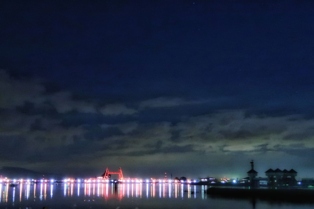 ILLUMINATED SEA AGAINST SKY AT NIGHT