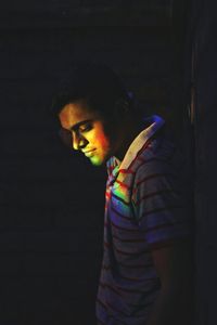 Young man standing in darkroom