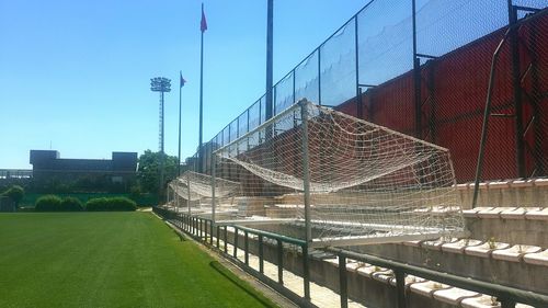 Soccer goals by field against clear blue sky