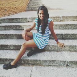 Portrait of smiling young woman sitting on steps