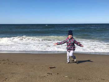 Full length of woman on beach against clear sky