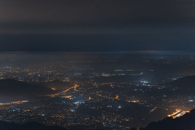 Aerial view of illuminated cityscape against sky at night