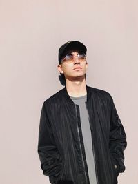 Portrait of young man standing against white background