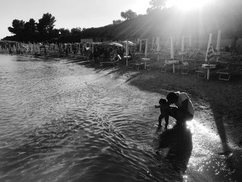 High angle view of father and daughter at beach against sky