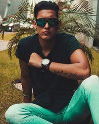 Portrait of man wearing sunglasses sitting outdoors