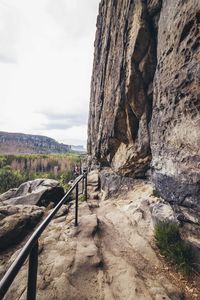 Rock formations by road against sky