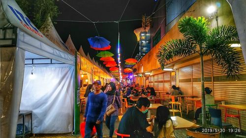 People in illuminated market at night