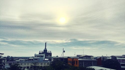 Buildings against cloudy sky