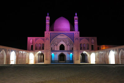 Illuminated building against sky at night